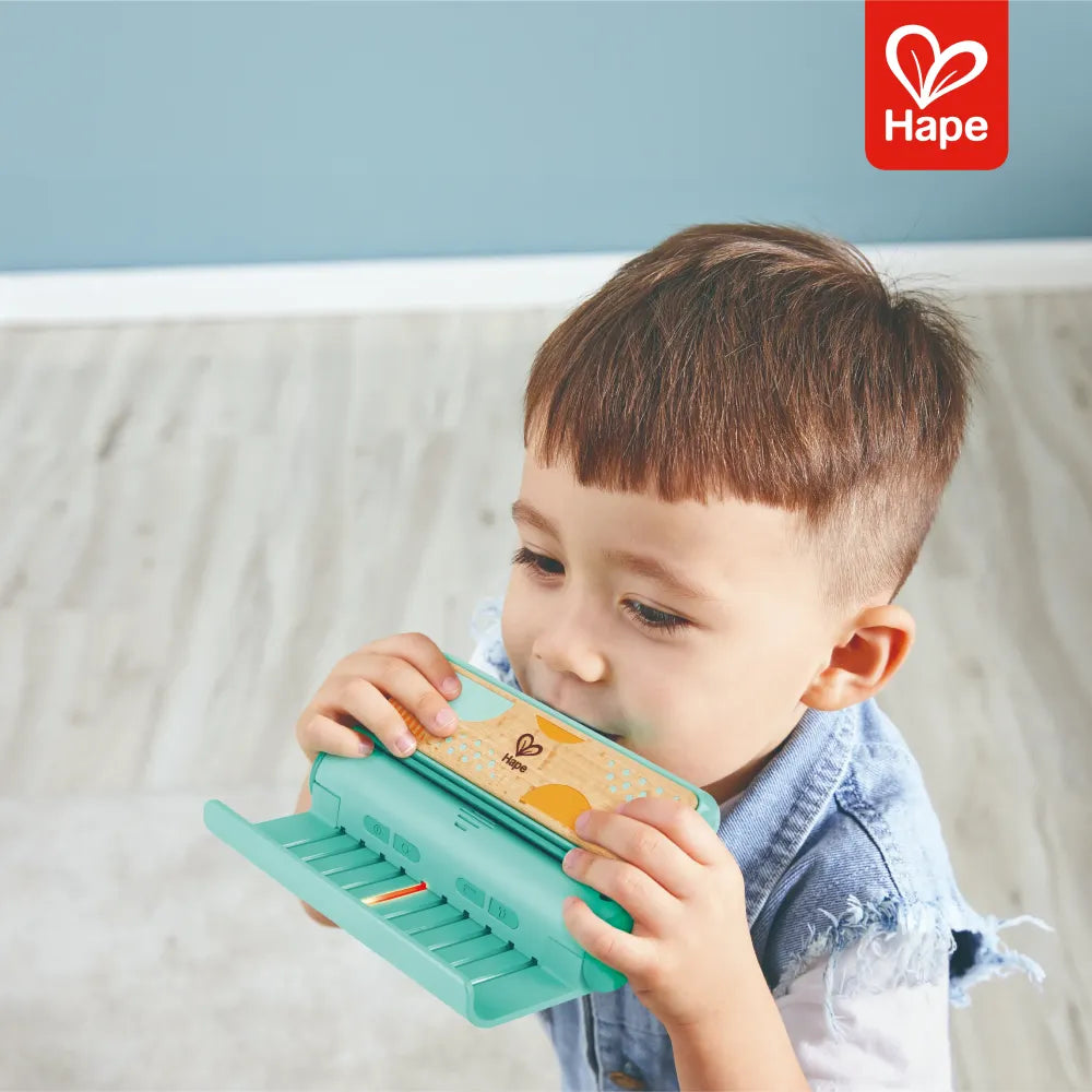 Criança tocando a Gaita Aprender com Luzes Hape