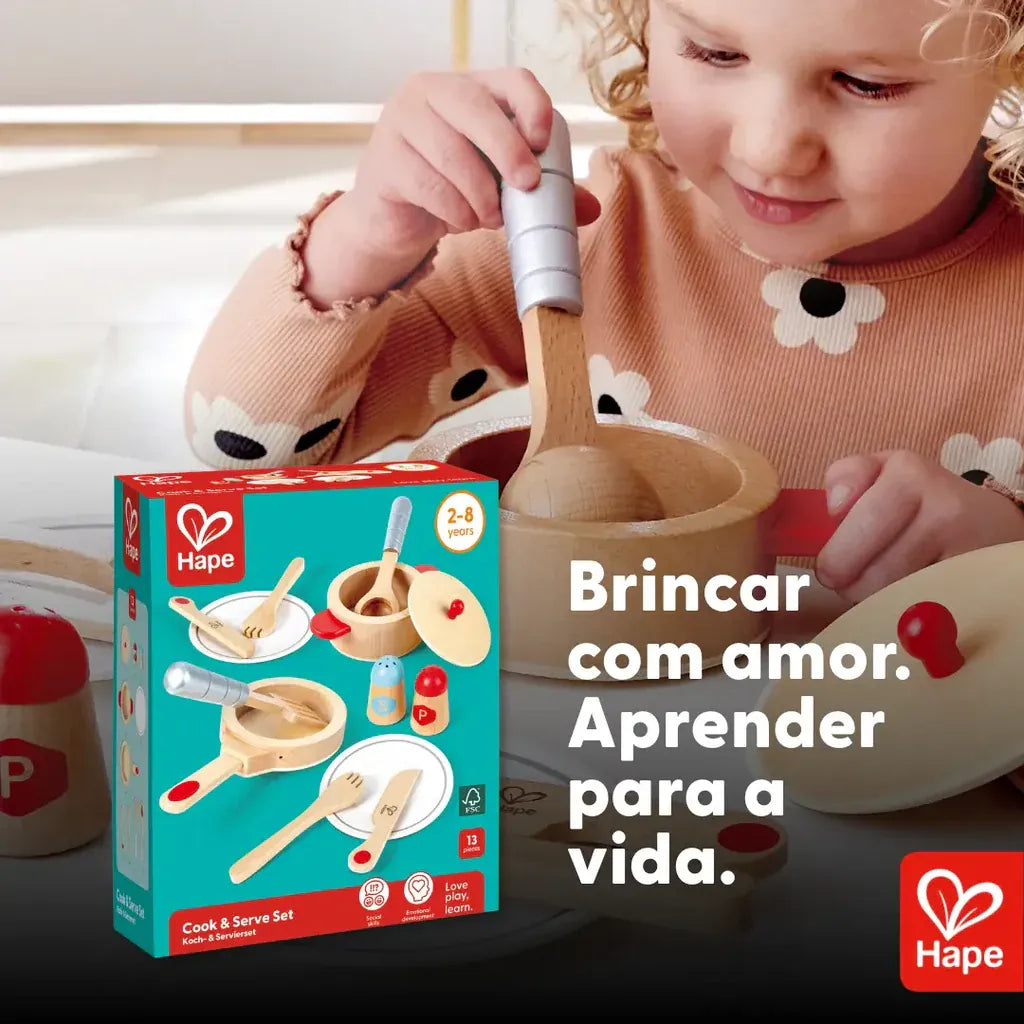 Menina brincando com as panelinhas de madeira Hape ao lado da embalagem do kit