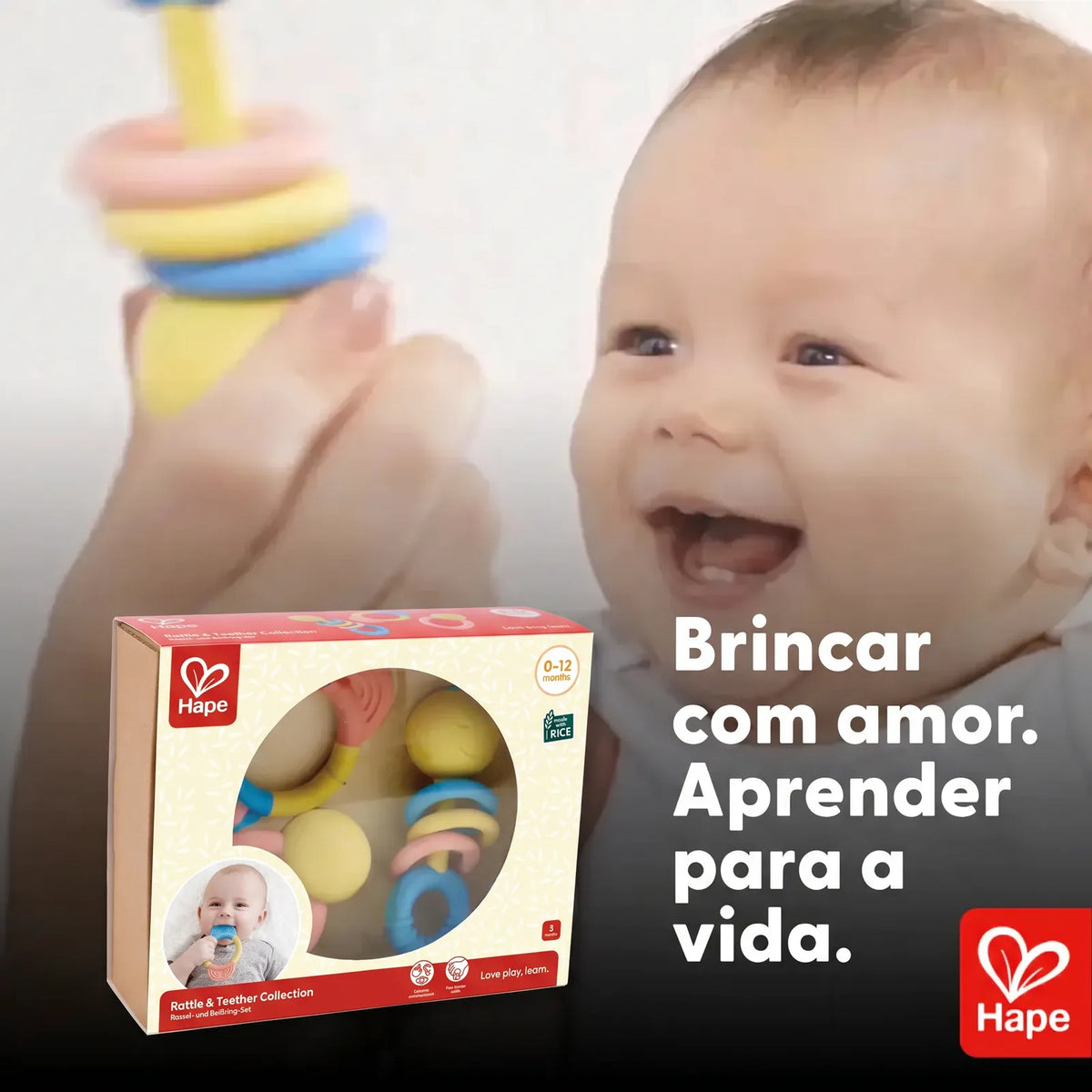 Bebê sorrindo com o chocalho Hape ao lado da embalagem do kit de mordedores