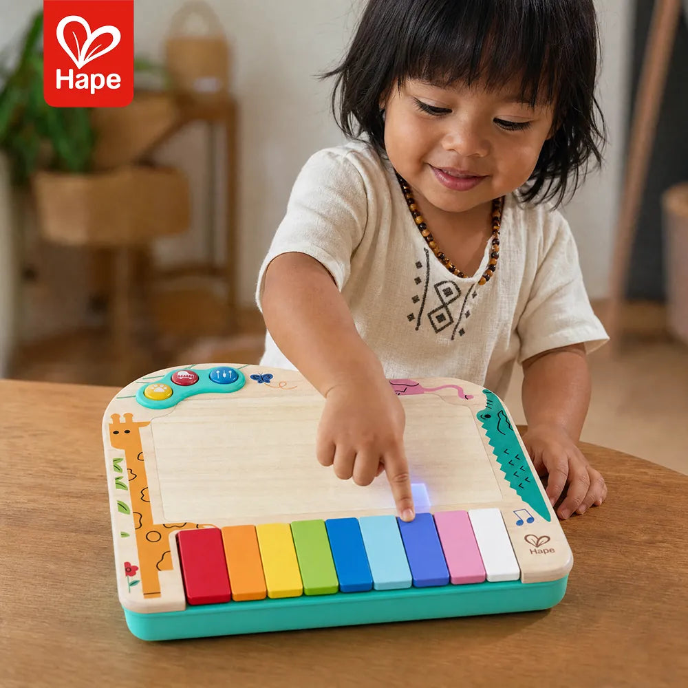 Menina tocando o piano de pixels Hape com a tela acesa